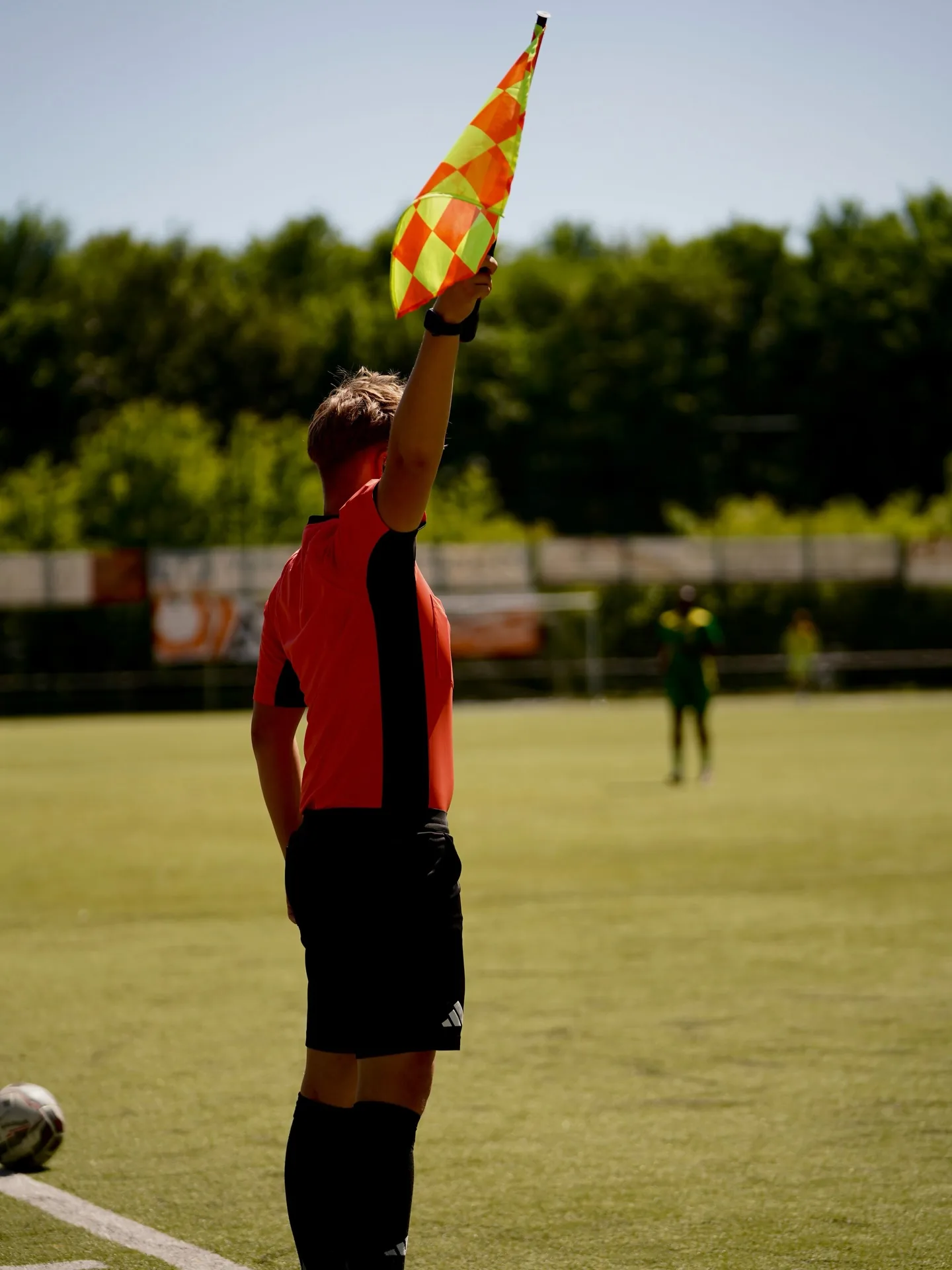 Schiedsrichter mit bunter Rauchfackel auf dem Fußballplatz
